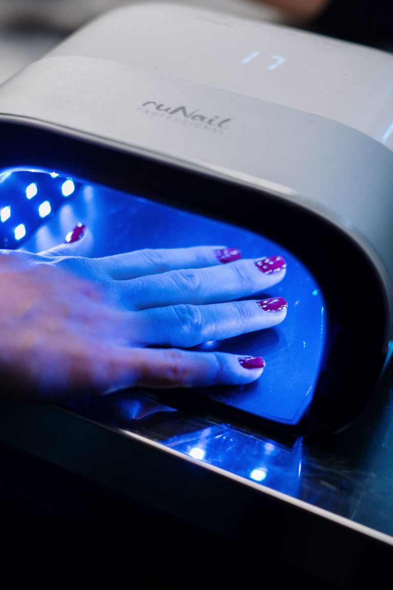 uv led nail lamp ,photo by : close-up of a UV LED lamp on a salon counter, hand inside curing